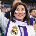 一位中年女性球迷，身穿皇马围巾